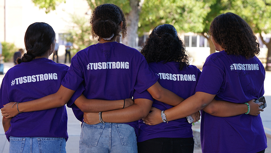 $ students, arms around each other with shirts that say TUSD Strong