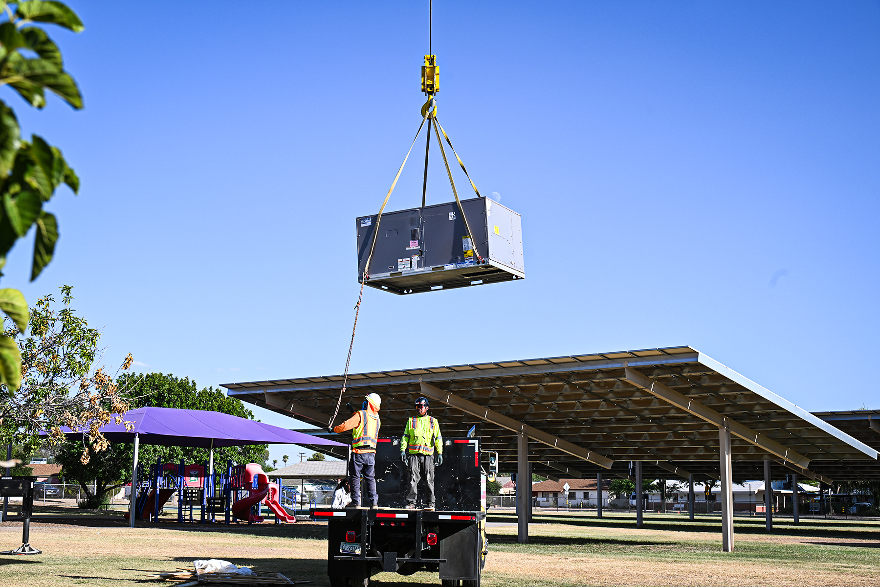 An air conditioner is suspended in the air above the solar panel shades