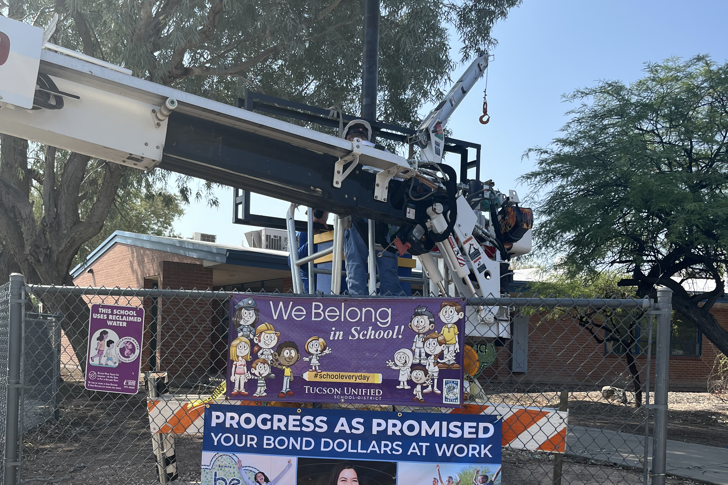 A construction worker stands in a cherry picker being used to install the new marquee