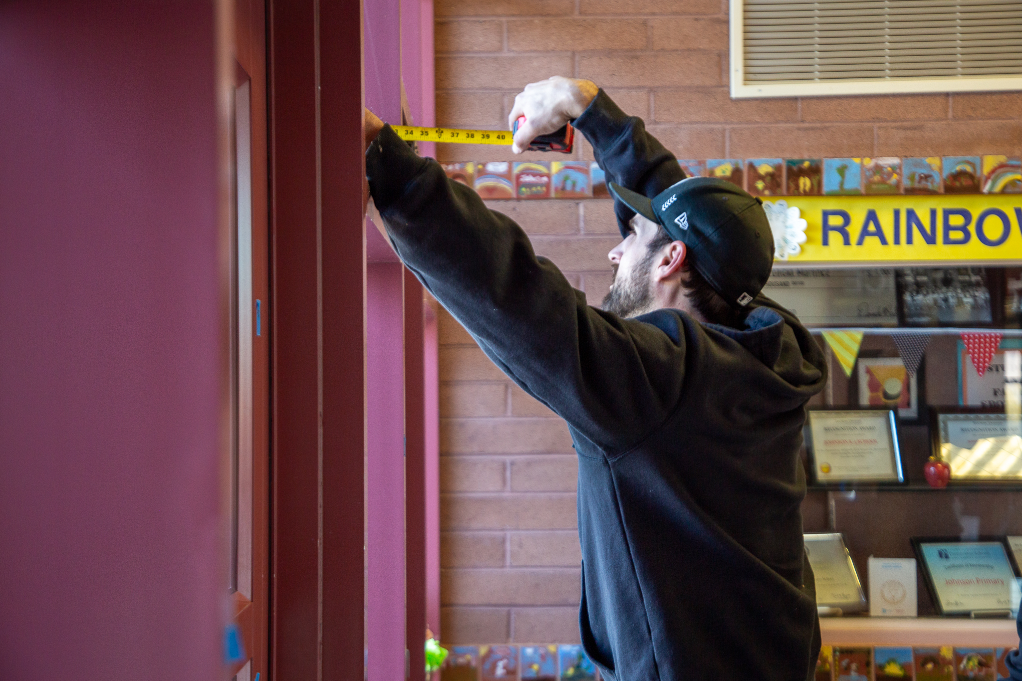 A man measures a window