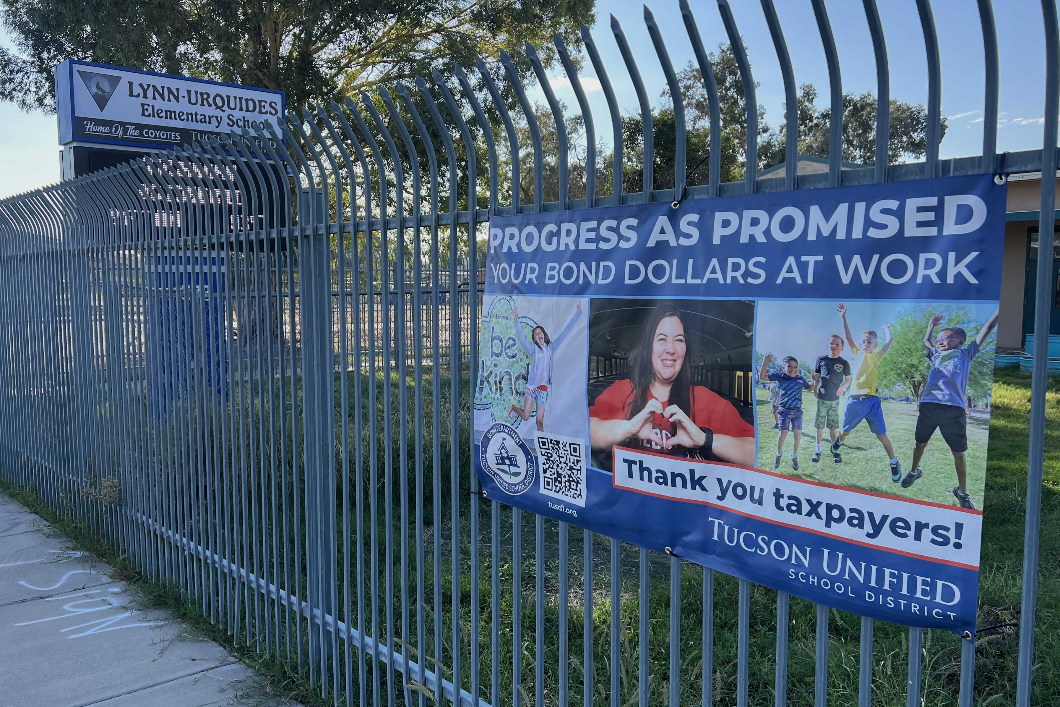 A fence outside Lynn Urquides with a banner reading Progress as Promised Your Bond Dollars at Work, Thank you taxpayers!