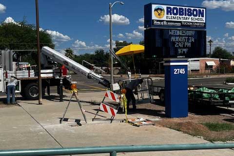 New marquee surrounded by construction equipment and crews standing by truck