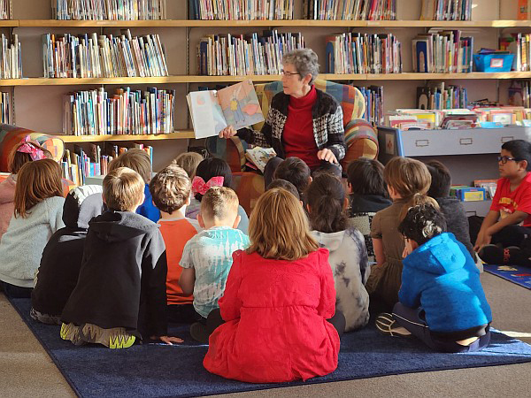 Students listening to teacher read a book